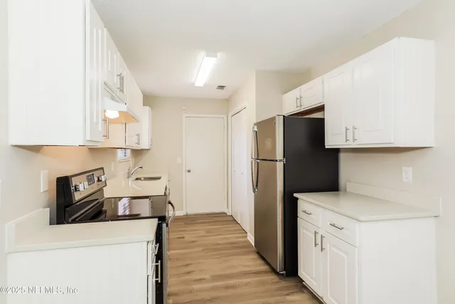 a kitchen with stainless steel appliances a refrigerator and a stove