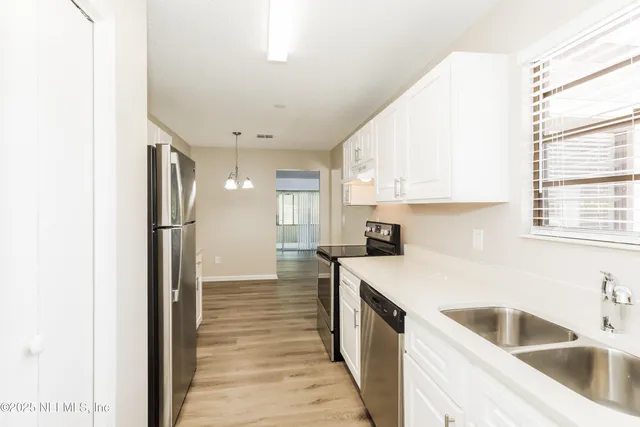 a kitchen with a sink a refrigerator and window