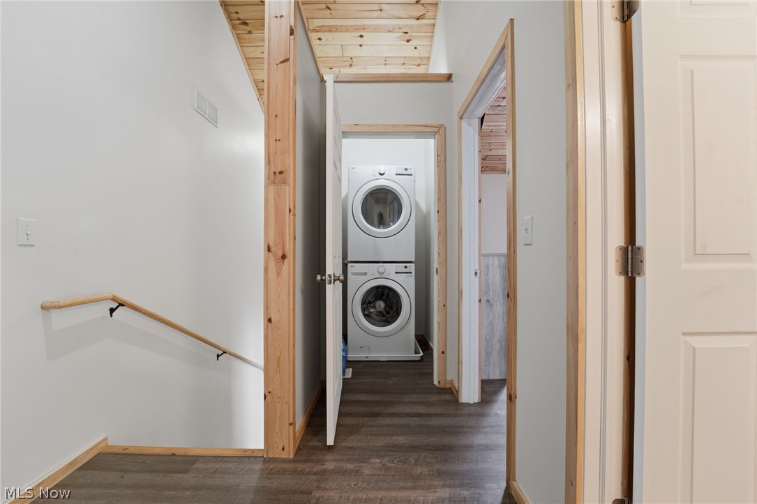 5919 Lake Road West, Unit 32 Ashtabula, OH 44004 - Photo 20 of 23 Laundry area with dark wood-type flooring, wooden ceiling, stacked washer and clothes dryer, and cooling unit
