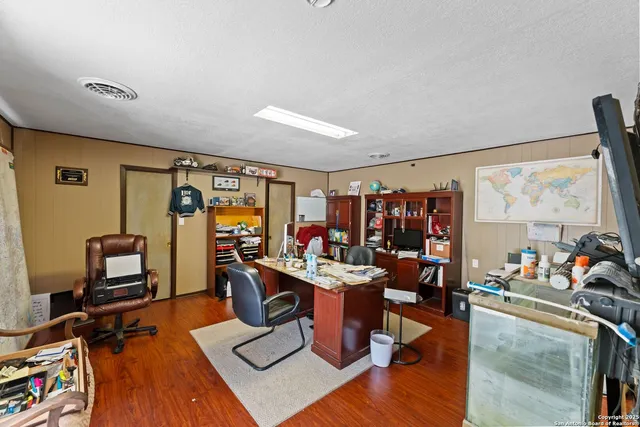 a work room with furniture a rug and a large window