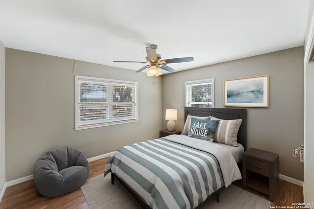a view of a room with wooden floor and a ceiling fan