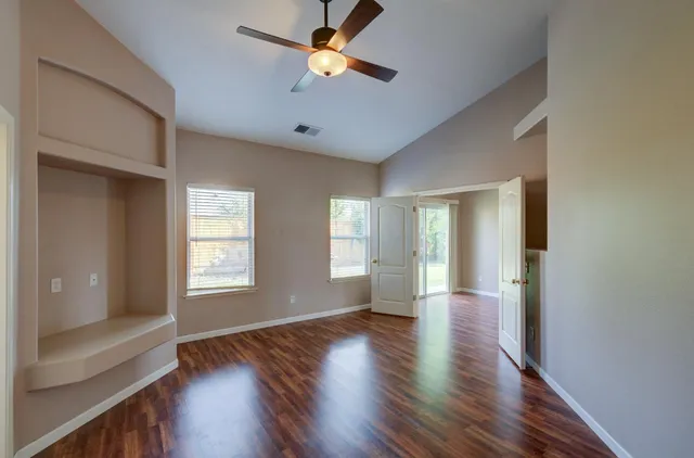 wooden floor in an empty room with a window