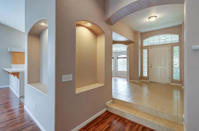a view of a hallway with wooden floor and staircase