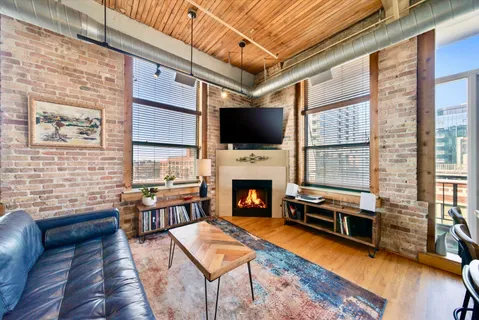 a living room with furniture a flat screen tv and a fireplace