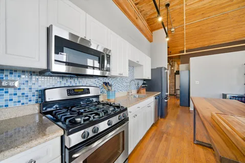 a kitchen with stainless steel appliances a stove a sink a microwave and cabinets
