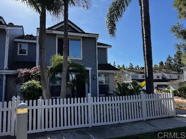 a view of a house with a small yard and deck