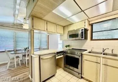 a kitchen with stainless steel appliances a stove sink and microwave
