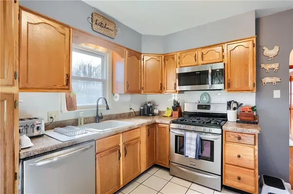 a kitchen with stainless steel appliances a stove sink microwave and cabinets