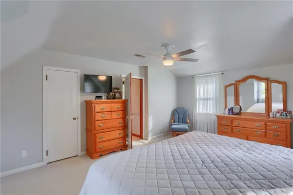 a bedroom with a bed a chair and chandelier
