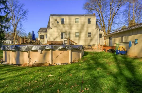 a view of swimming pool of water with lawn chairs and iron fence