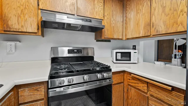 a kitchen with stainless steel appliances granite countertop a stove and a microwave