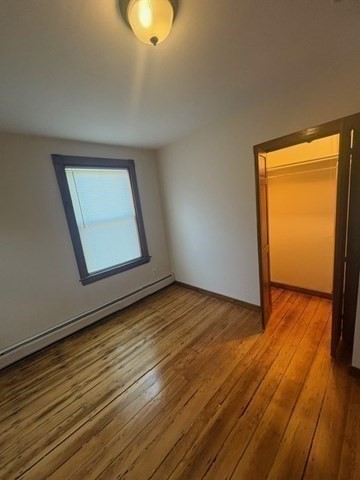 5 Oakland Street Boston, MA 02119 - Photo 11 of 21 a view of an empty room with wooden floor and a window
