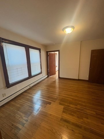 5 Oakland Street Boston, MA 02119 - Photo 12 of 21 a view of an empty room with wooden floor and cabinet