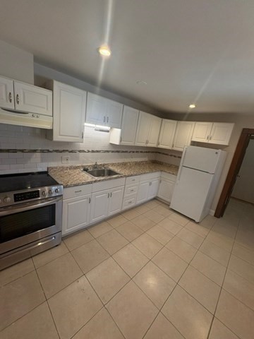 5 Oakland Street Boston, MA 02119 - Photo 5 of 21 a kitchen with a stove a sink and a refrigerator