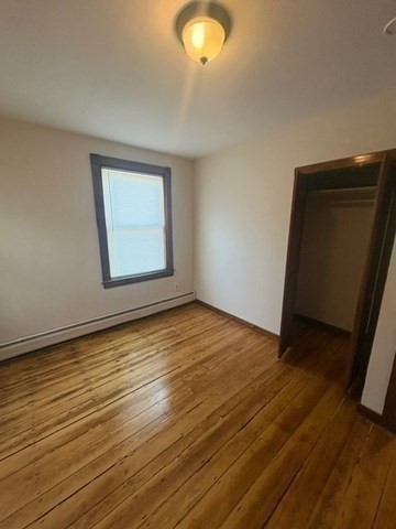 5 Oakland Street Boston, MA 02119 - Photo 9 of 21 an empty room with wooden floor and windows