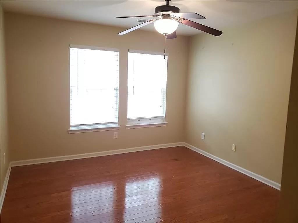 3050 A Centerglen Lane Cumming, GA 30040 - Photo 4 of 10 an empty room with wooden floor windows and fan