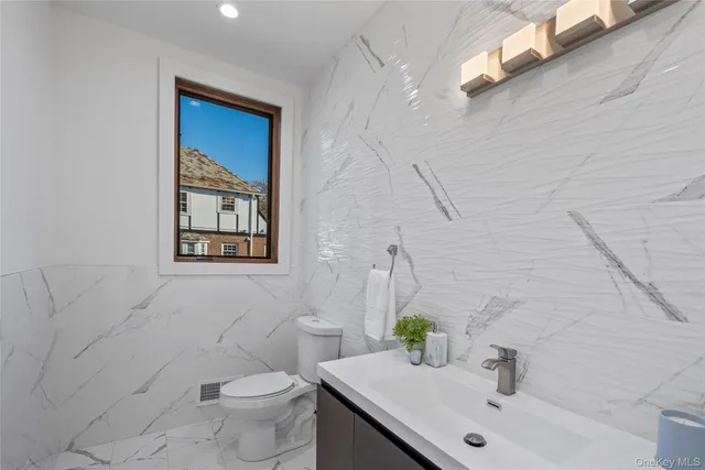 a bathroom with a sink mirror and toilet