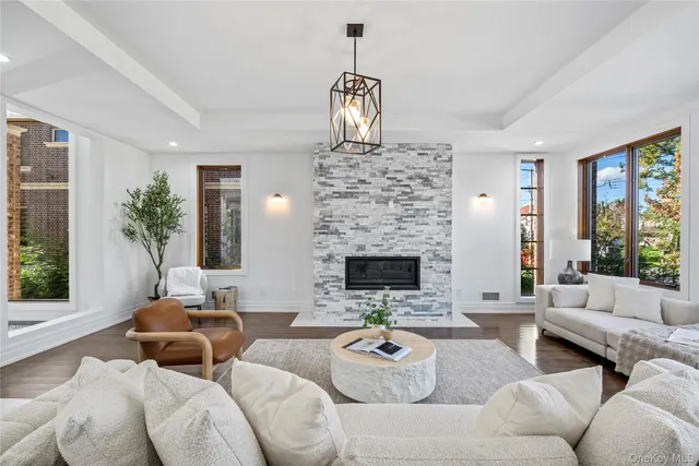 a living room with furniture chandelier and a fireplace