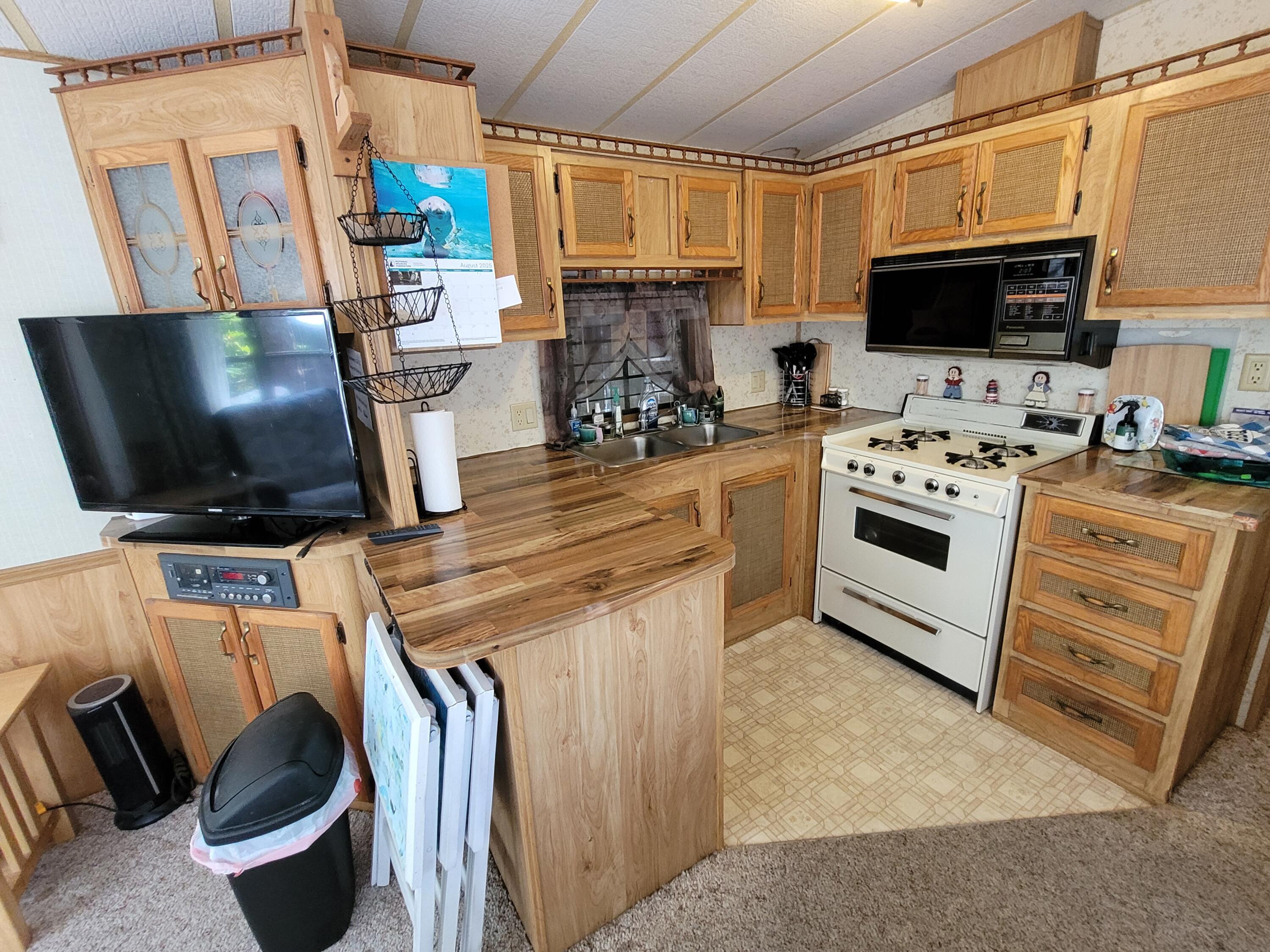 310 Old Chatham Road, Unit H12 South Dennis, MA 02660 - Photo 45 of 55 a kitchen with stainless steel appliances a stove a microwave a sink and a counter