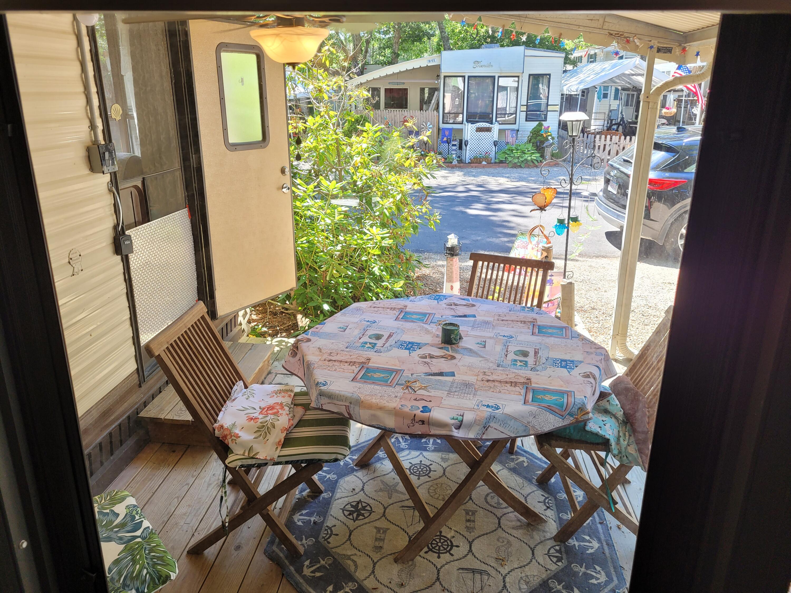 310 Old Chatham Road, Unit H12 South Dennis, MA 02660 - Photo 54 of 55 a view of a patio with table and chairs and wooden floor
