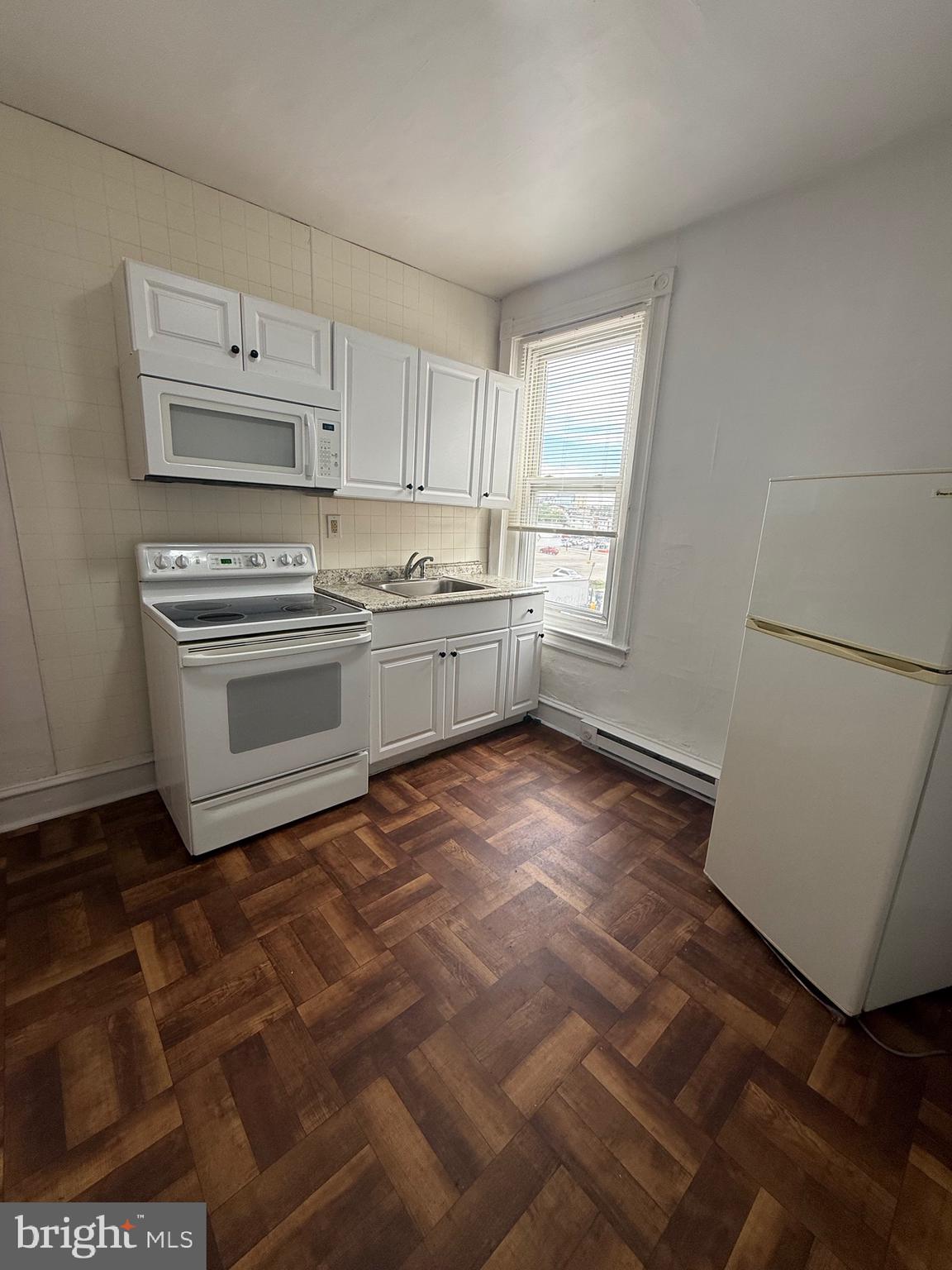 5700 Chestnut Street, Unit 3A Philadelphia, PA 19139 - Photo 3 of 8 a kitchen with stainless steel appliances a stove a sink and white cabinets