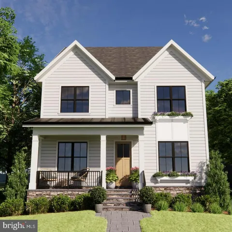 a front view of a house with garage and plants