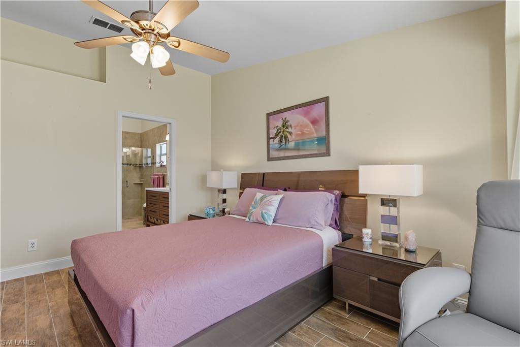 2266 Stacil Circle, Unit 3 Naples, FL 34109 - Photo 30 of 49 Bedroom featuring wood tiled floors, a ceiling fan, and connected bathroom