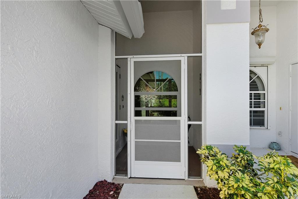 2266 Stacil Circle, Unit 3 Naples, FL 34109 - Photo 37 of 49 View of exterior entry with stucco siding