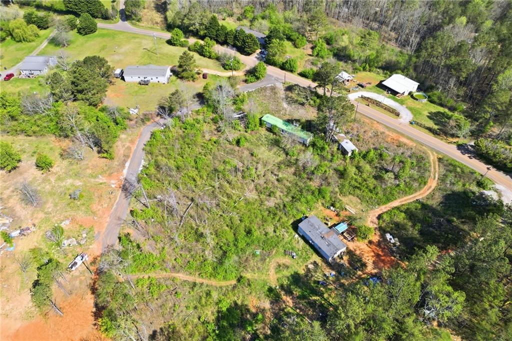 an aerial view of residential house with outdoor space and trees all around