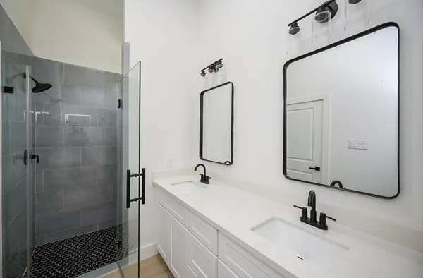 a bathroom with double vanity sink and a mirror