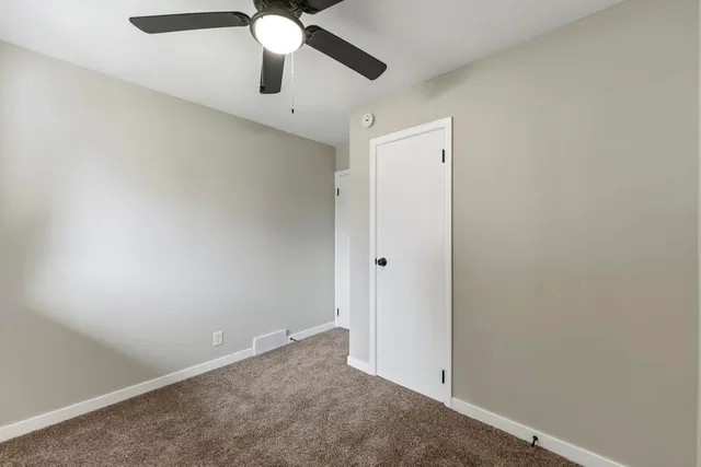 an empty room with chandelier fan