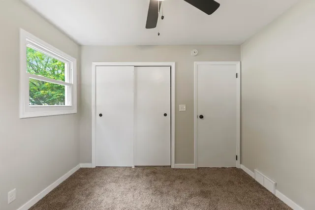 an empty room with windows and closet