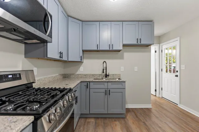 a kitchen with stainless steel appliances granite countertop a stove a sink and a refrigerator