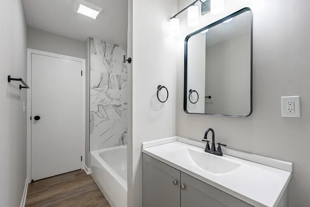 a bathroom with a tub sink and mirror