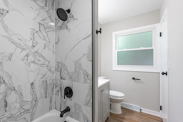 a bathroom with a toilet and a shower