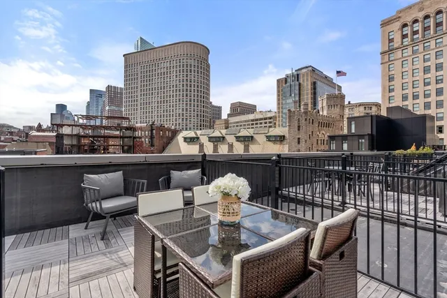 a roof deck with couches and wooden floor
