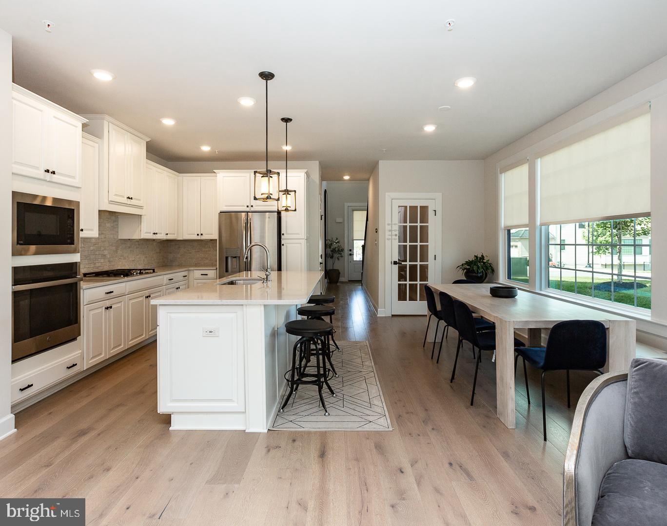 21 The Lane Wayne, PA 19087 - Photo 11 of 57 a large kitchen with lots of counter space dining table and stainless steel appliances