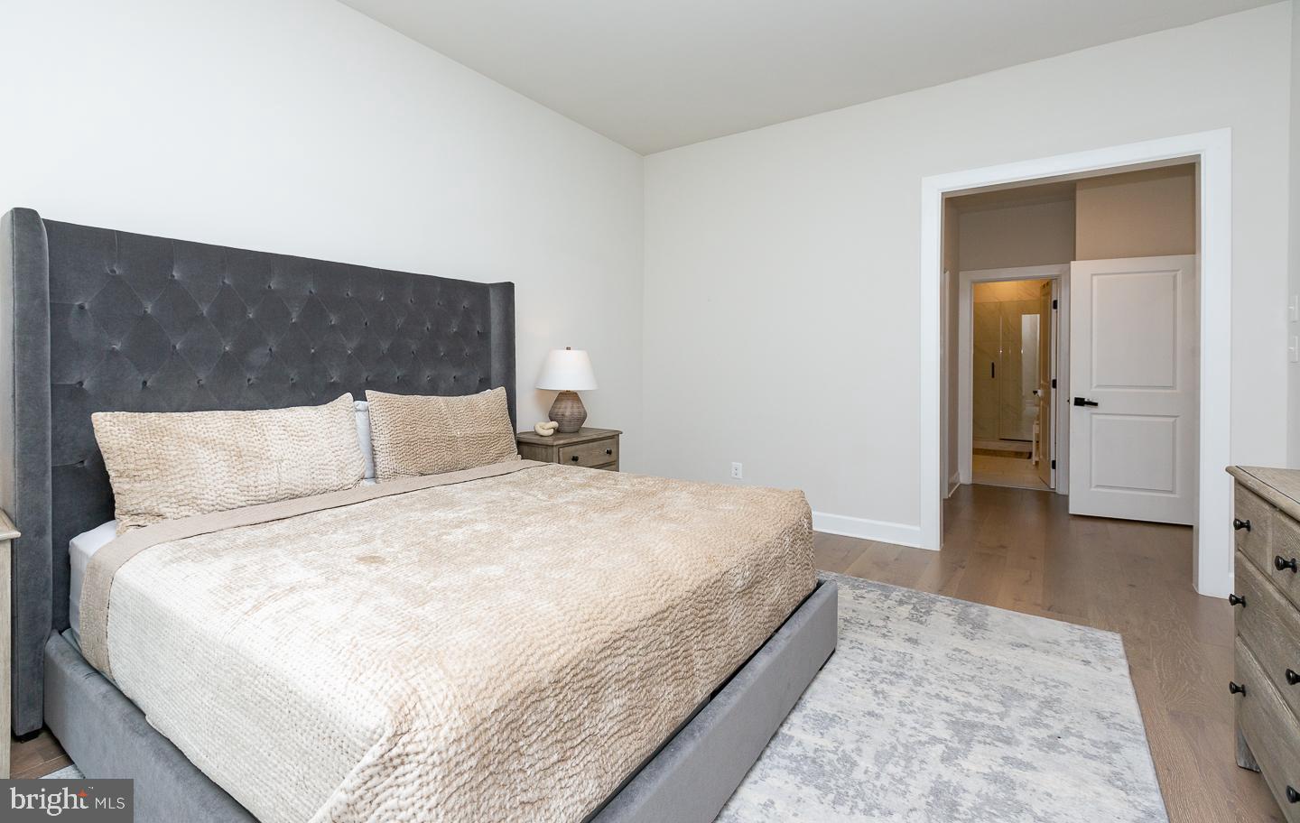 21 The Lane Wayne, PA 19087 - Photo 18 of 57 a large bed in a white room with wooden floor