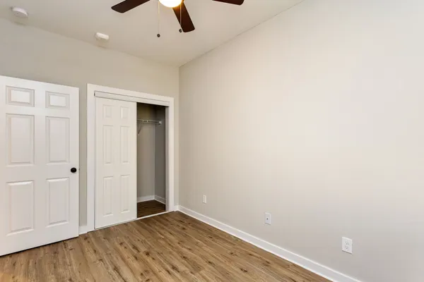 an empty room with ceiling fan and window