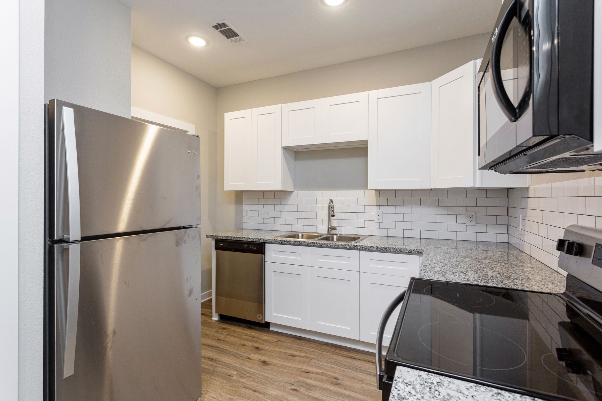 10317 Lake Road, Unit 12C Houston, TX 77070 - Photo 9 of 33 a kitchen with a refrigerator sink and cabinets