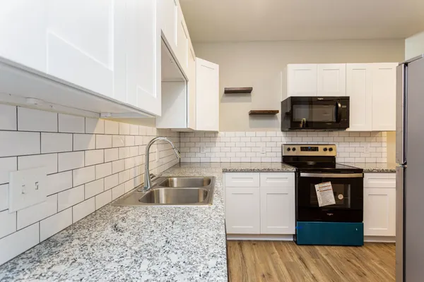 a kitchen with a sink stove and microwave