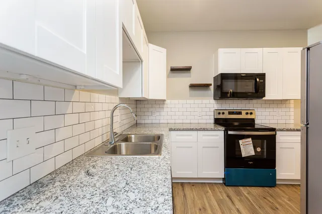 a kitchen with a sink stove and microwave