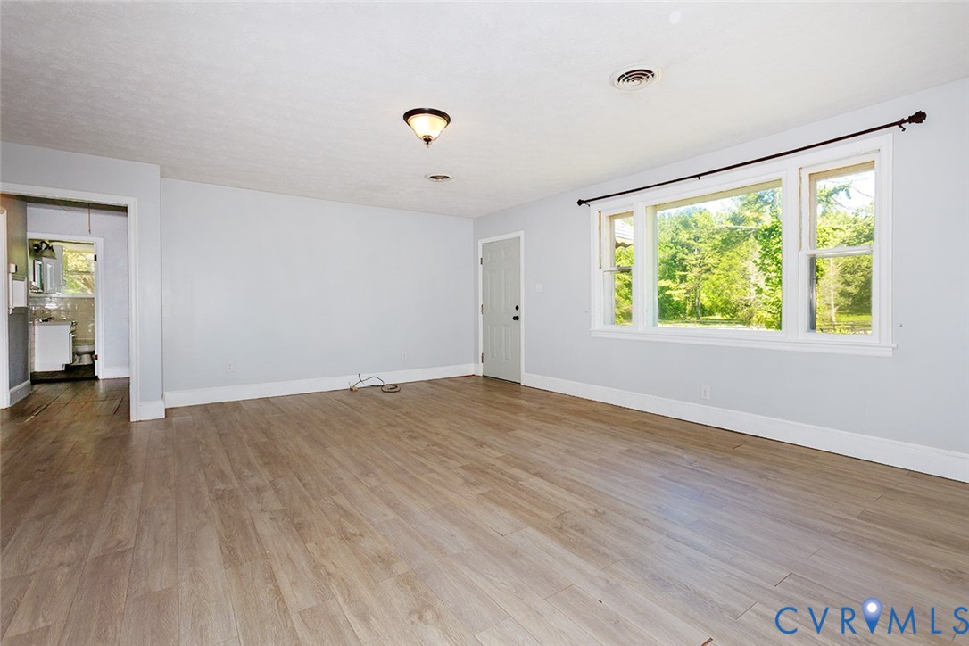 9903 Boze Road Ford, VA 23850 - Photo 9 of 45 an empty room with wooden floor and windows