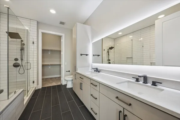 a spacious bathroom with a shower sink and mirror