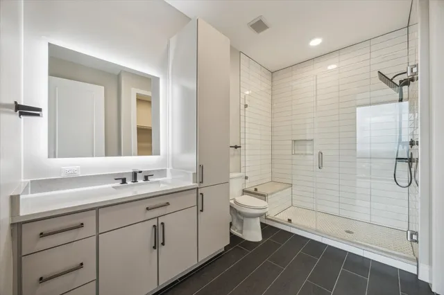 a bathroom with a double vanity sink toilet and shower