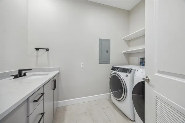 a utility room with sink dryer and washer
