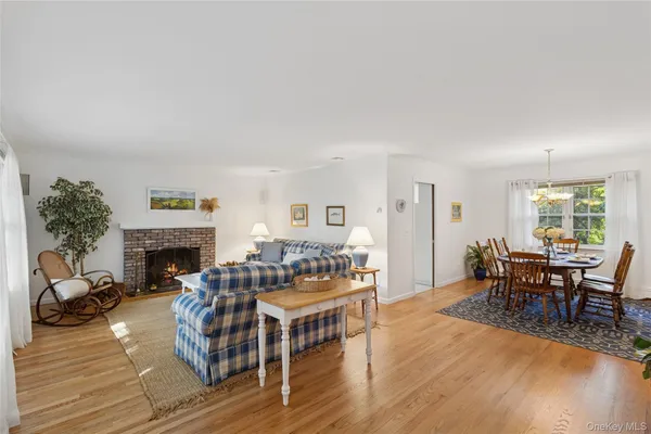 a dining room with furniture a large window and wooden floor