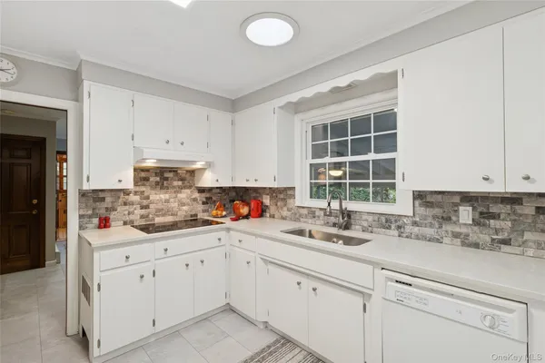 a kitchen with cabinets appliances a sink and a window