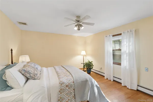 a bedroom with a bed lamp and a potted plant