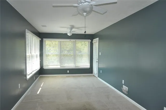 a view of a livingroom with a ceiling fan and window